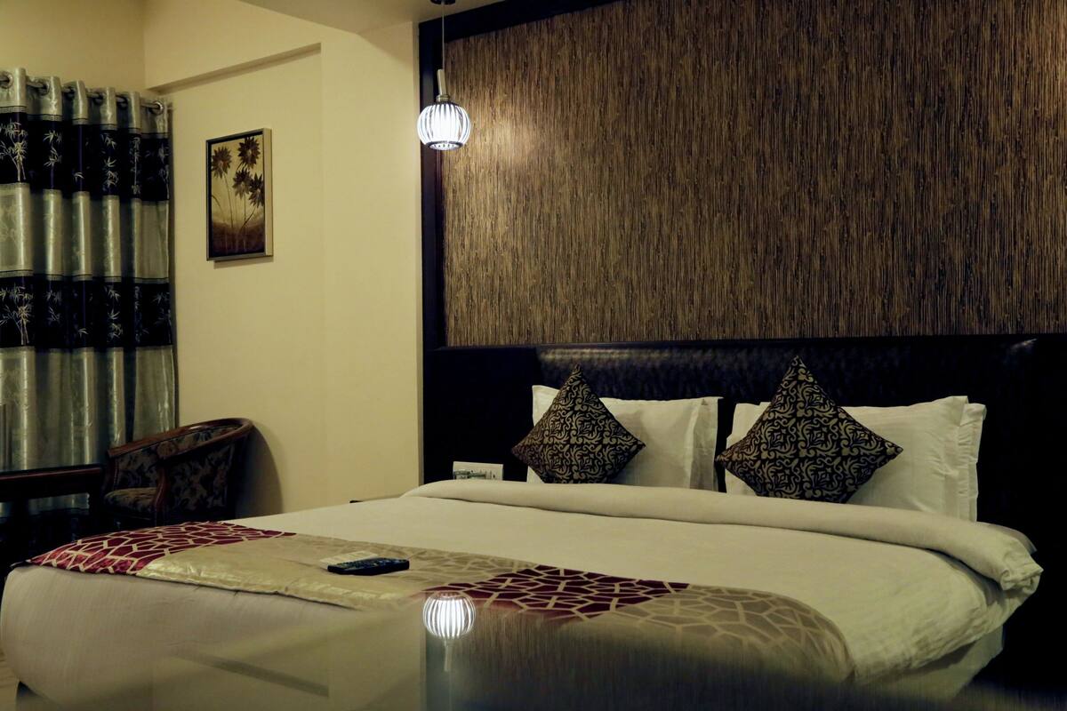 Ein Hotelzimmer mit einem großen Bett, einem Holzkopfende und einem Nachttisch mit einer Lampe.