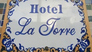 A sign with the text "Hotel La Torre" surrounded by decorative blue patterns. - Hotel La Torre Butantã (São Paulo)