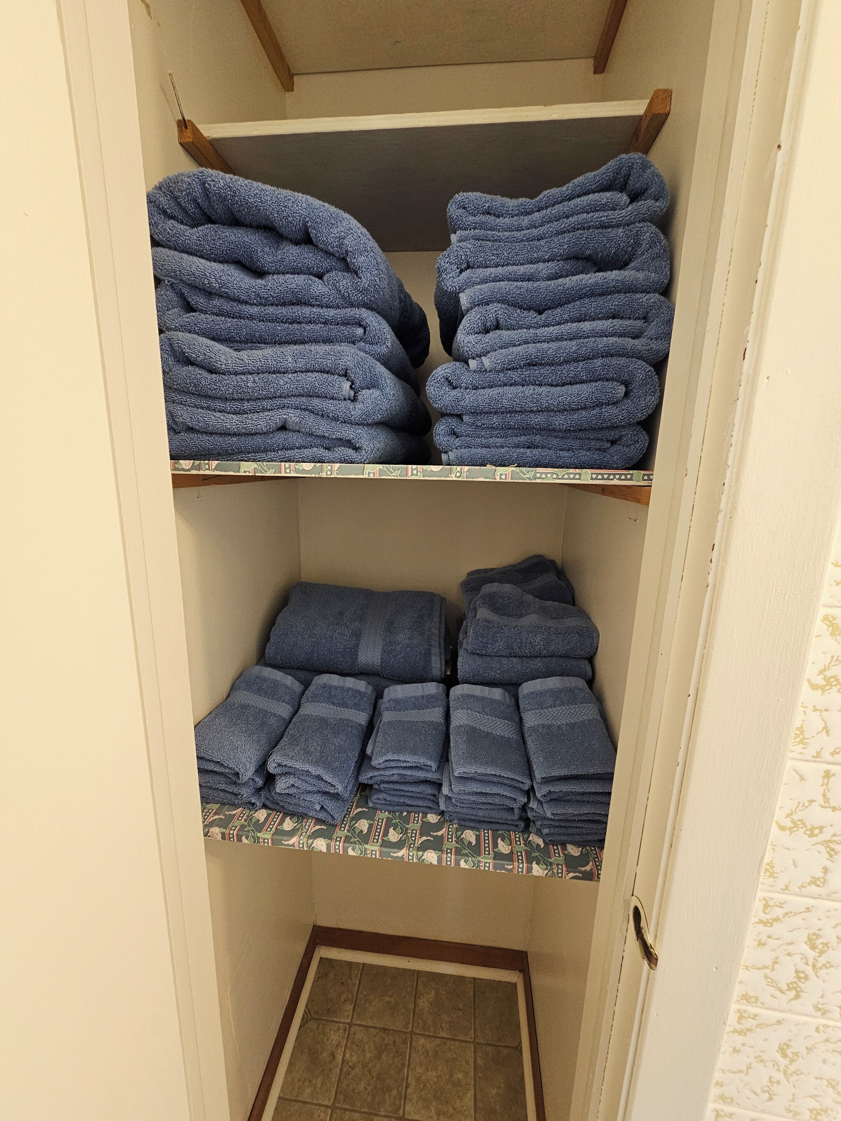 A storage area with shelves holding folded towels.