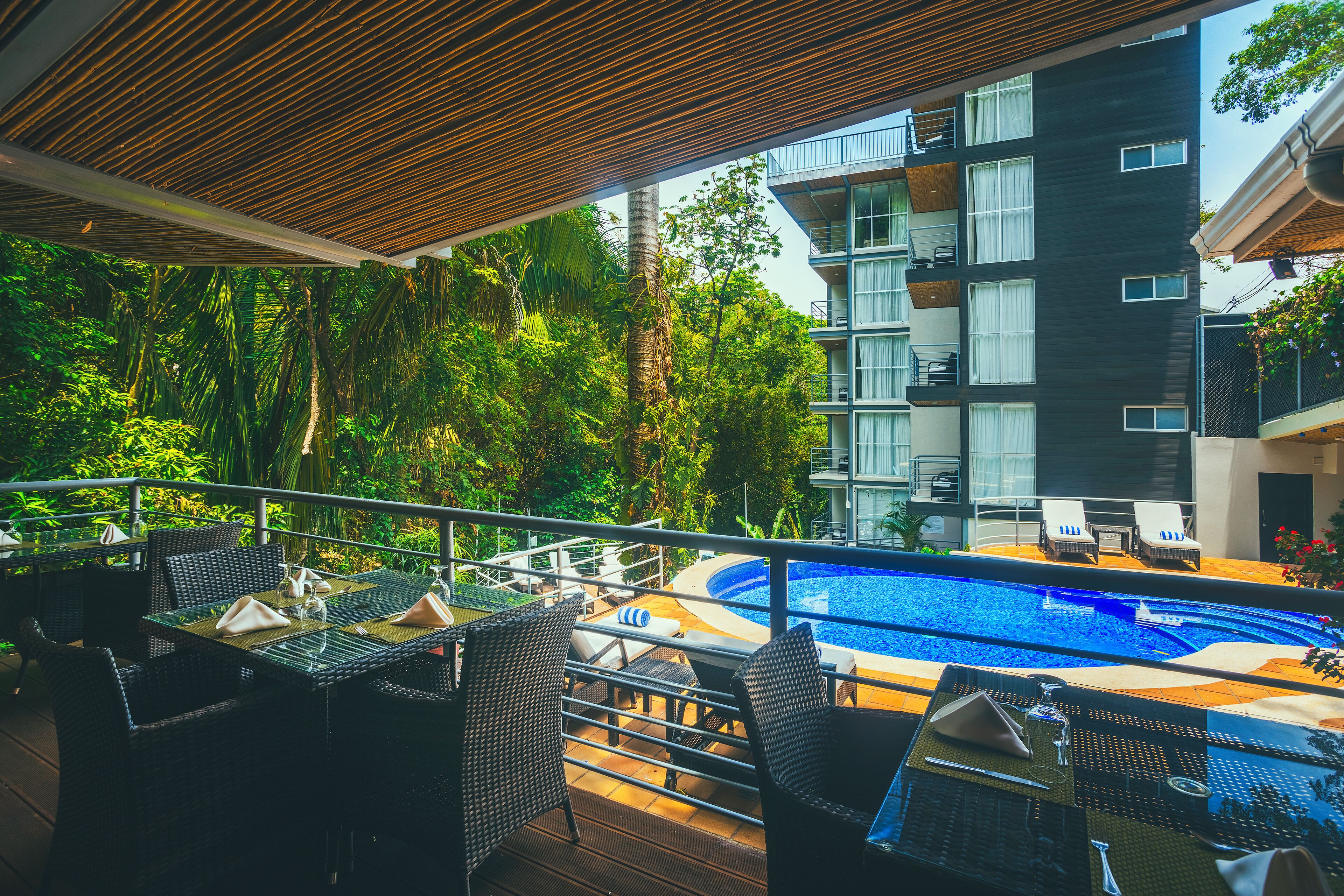 A poolside area with outdoor seating and a view of a modern building.