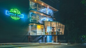 Un edificio de varios pisos con un letrero de neón que dice 'Jungle Vista Boutique Hotel'.