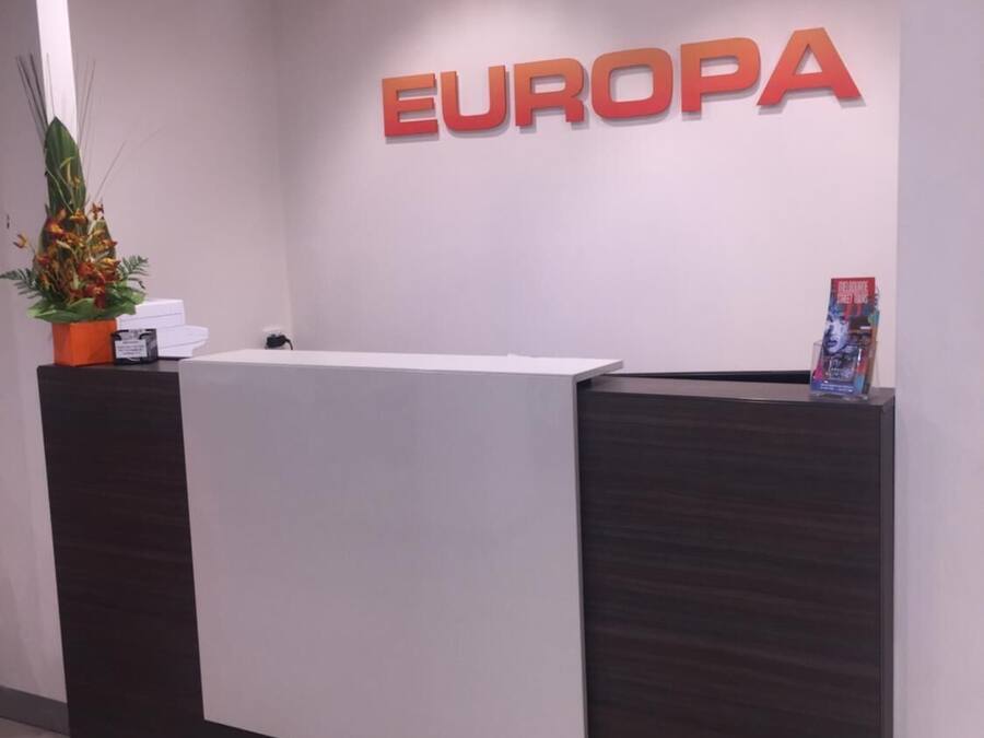 Uma mesa de recepção com uma placa que diz "EUROPA" em cima.