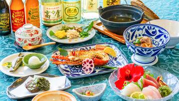 Et bord med forskellige retter, heriblandt fisk og skaldyr samt et traditionelt japansk tesæt.