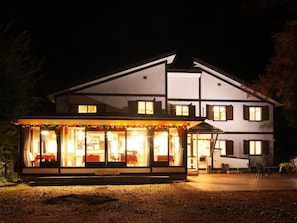 A two-story building with a covered front area, possibly a restaurant or cafe, and a visible outdoor seating area.