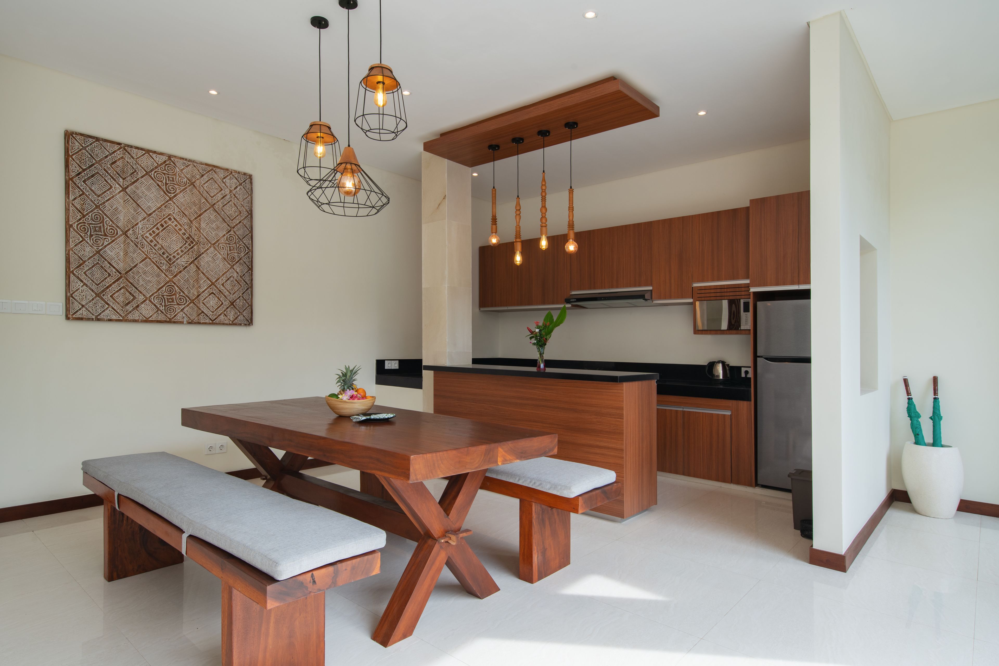 A modern kitchen with wooden cabinets, a central island, and pendant lighting.