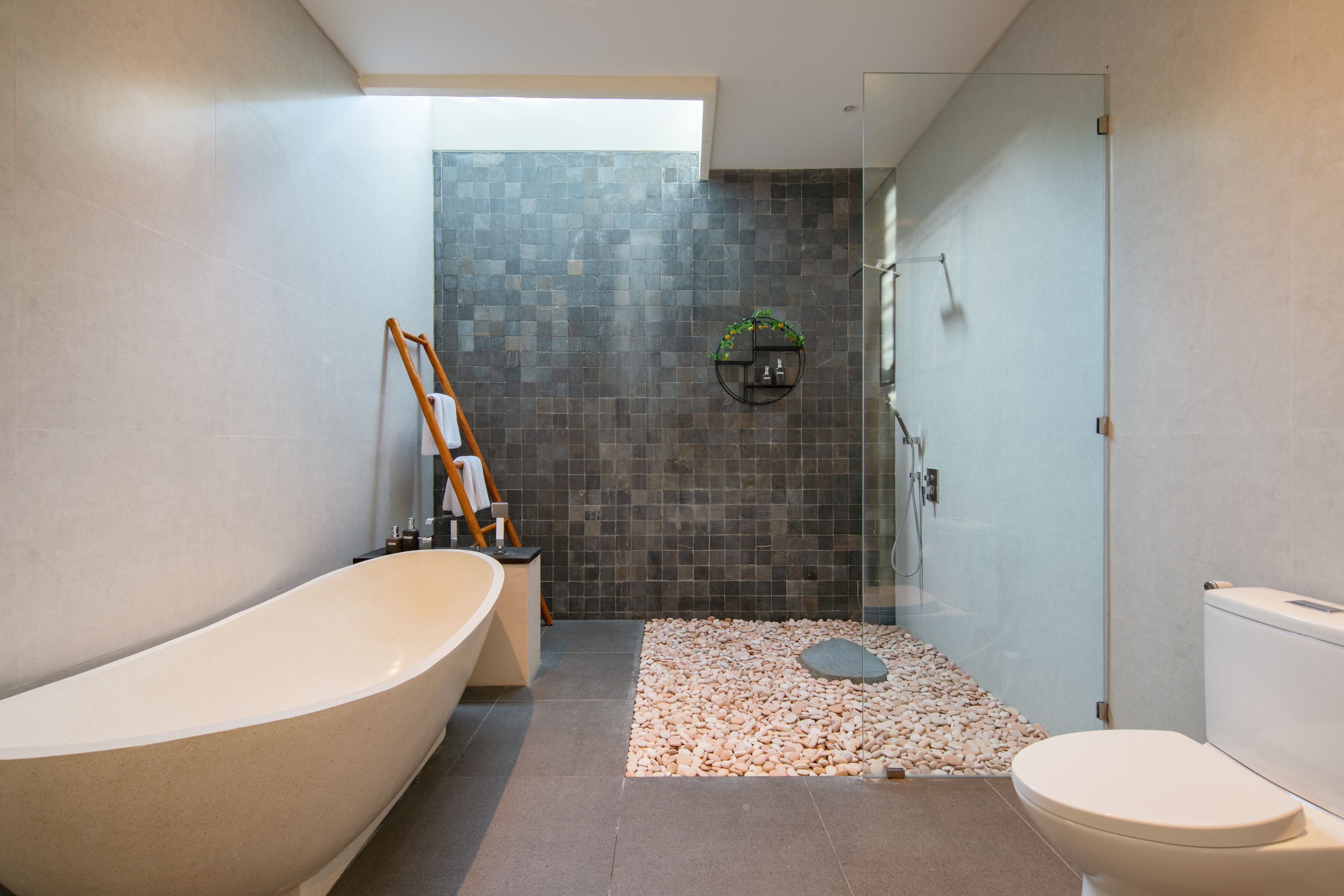 A modern bathroom with a freestanding bathtub, a glass-enclosed shower, and a toilet.
