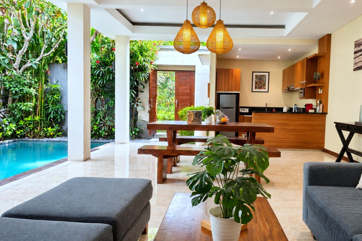 A modern living area with a pool, dining table, and seating.