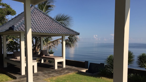 Ein überdachter Sitzbereich mit Blick auf das Meer.