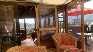 A cozy room with wicker furniture, a glass table, and a view of the outdoors. - Hakuba Ski Condos (Hakuba)