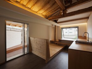 A modern kitchen with wooden beams, a large window, and a sink. - Hanok Residence Hotel Side (Seoul)