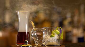 A bar setting with a clear glass, a glass of red liquid, and a glass with ice and lime.