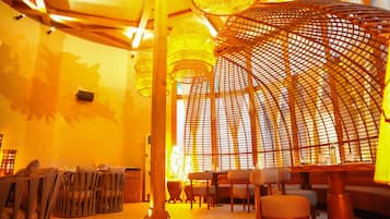 Un restaurante con mobiliario de madera, una columna central y una estructura de techo curva.