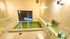 Une salle de bain moderne avec une grande baignoire, un espace douche et un petit marchepied.