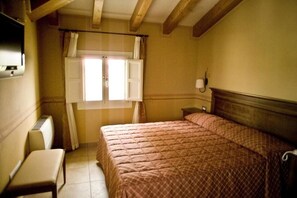 Suite junior, hidromasaje | Edredón, minibar, caja de seguridad en la habitación y escritorio