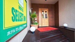 A hotel entrance with a wooden door, a red carpet, and a signboard. - Hotel Select Inn Shimada Ekimae (Shimada)
