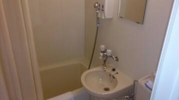 Un baño pequeño con bañera, lavamanos y espejo.