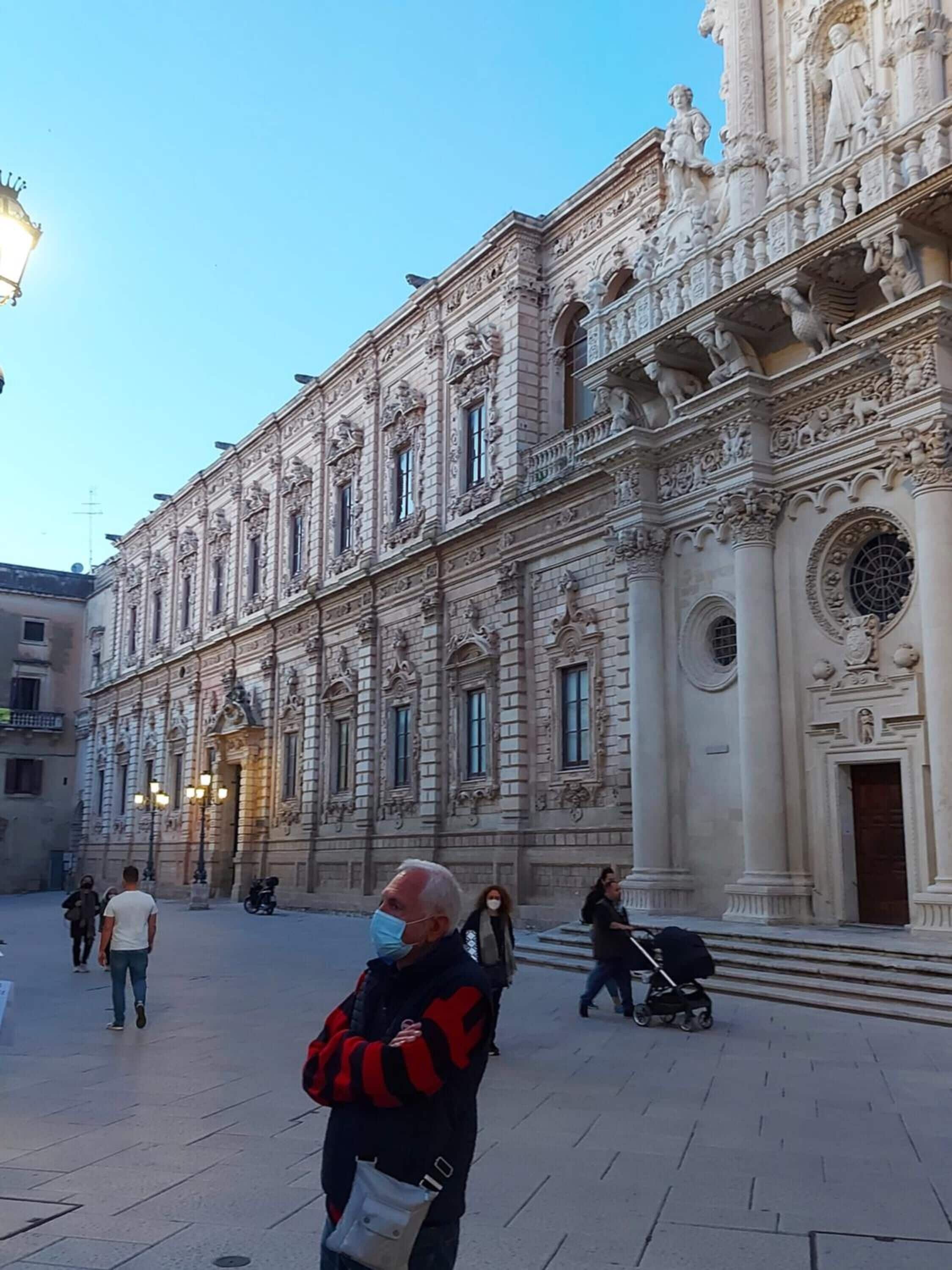 A historic building with ornate architectural details, including statues and columns.