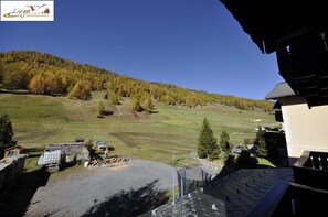 A view of a mountainous area with a building in the foreground and a clear sky. - Casa Florin (Livigno)