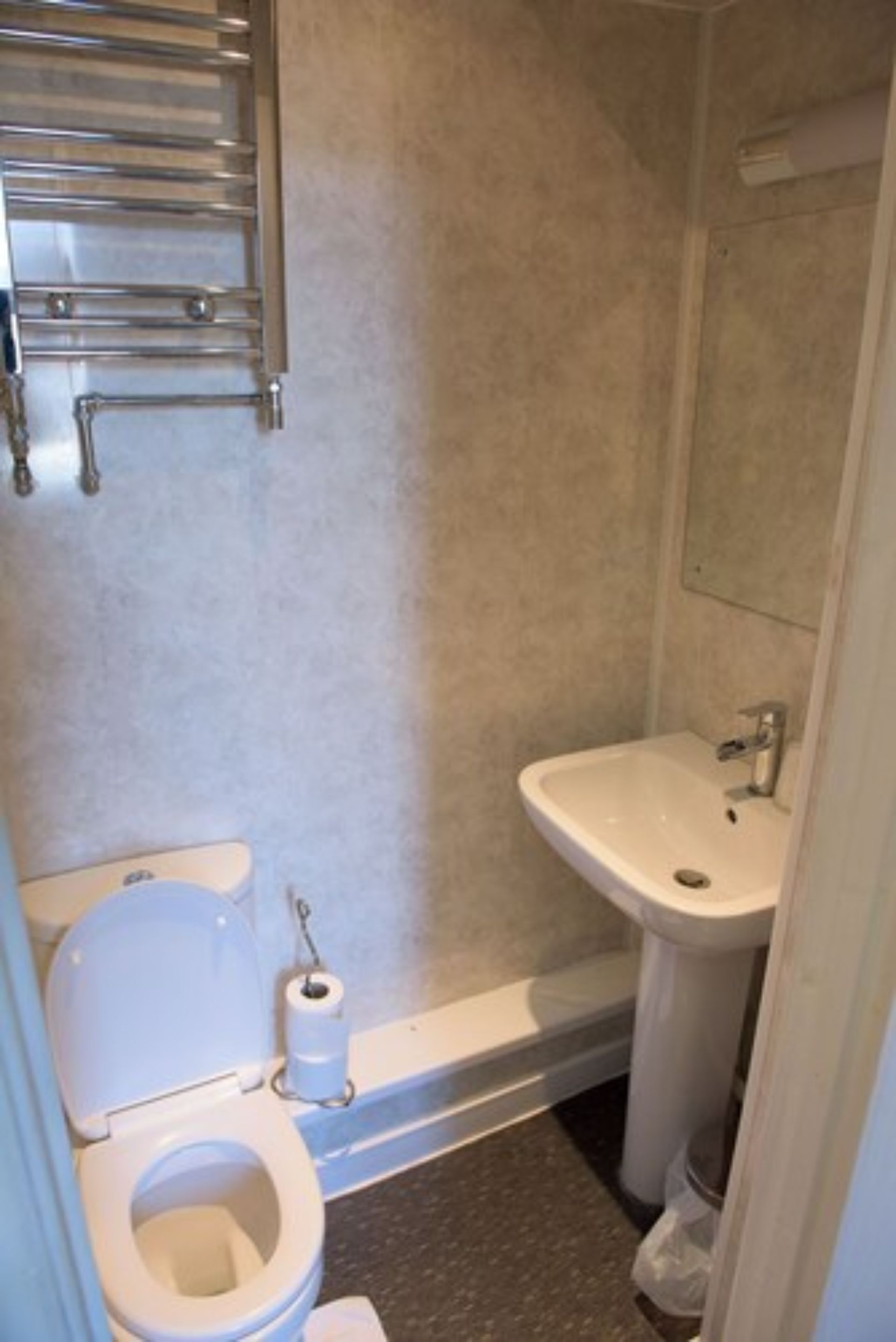 Une salle de bain avec des toilettes, un lavabo et une douche.