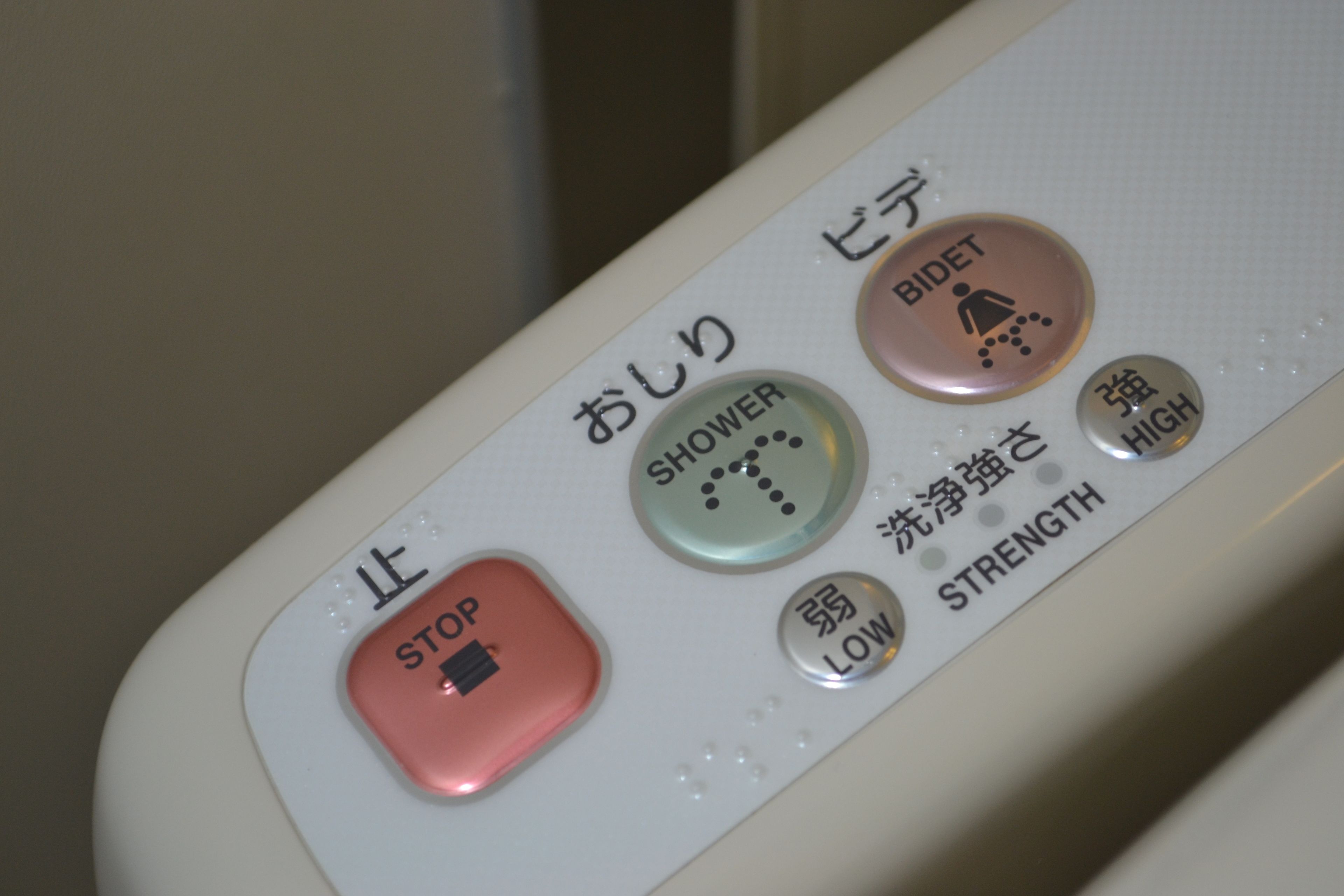 Un panneau de commande doté de boutons portant les inscriptions « ARRÊT », « DOUCHE », « BIDET » et « INTENSITÉ ».
