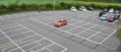 A parking lot with marked spaces and a small building in the background.