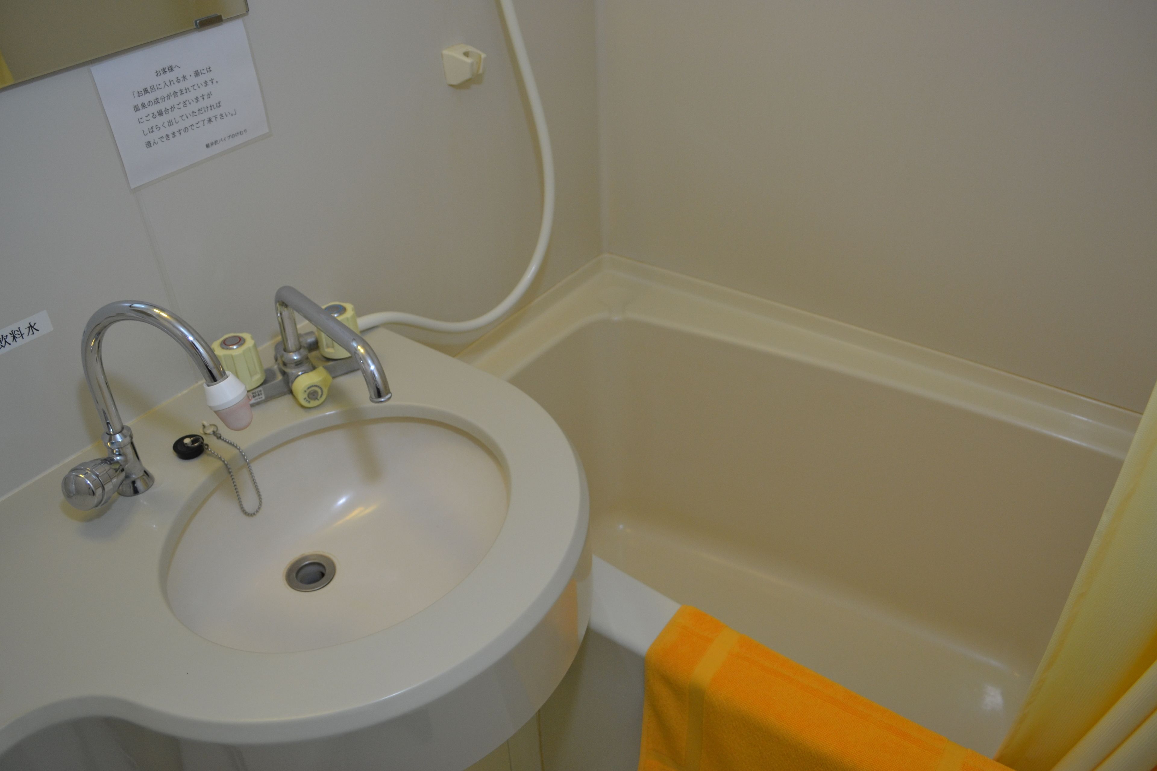 A bathroom with a sink, faucet, and a bathtub.