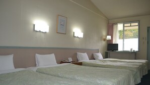 A hotel room with four beds, a television on a desk, and a window with curtains. - Karuizawa Hotel PAIPU NO KEMURI (Karuizawa)