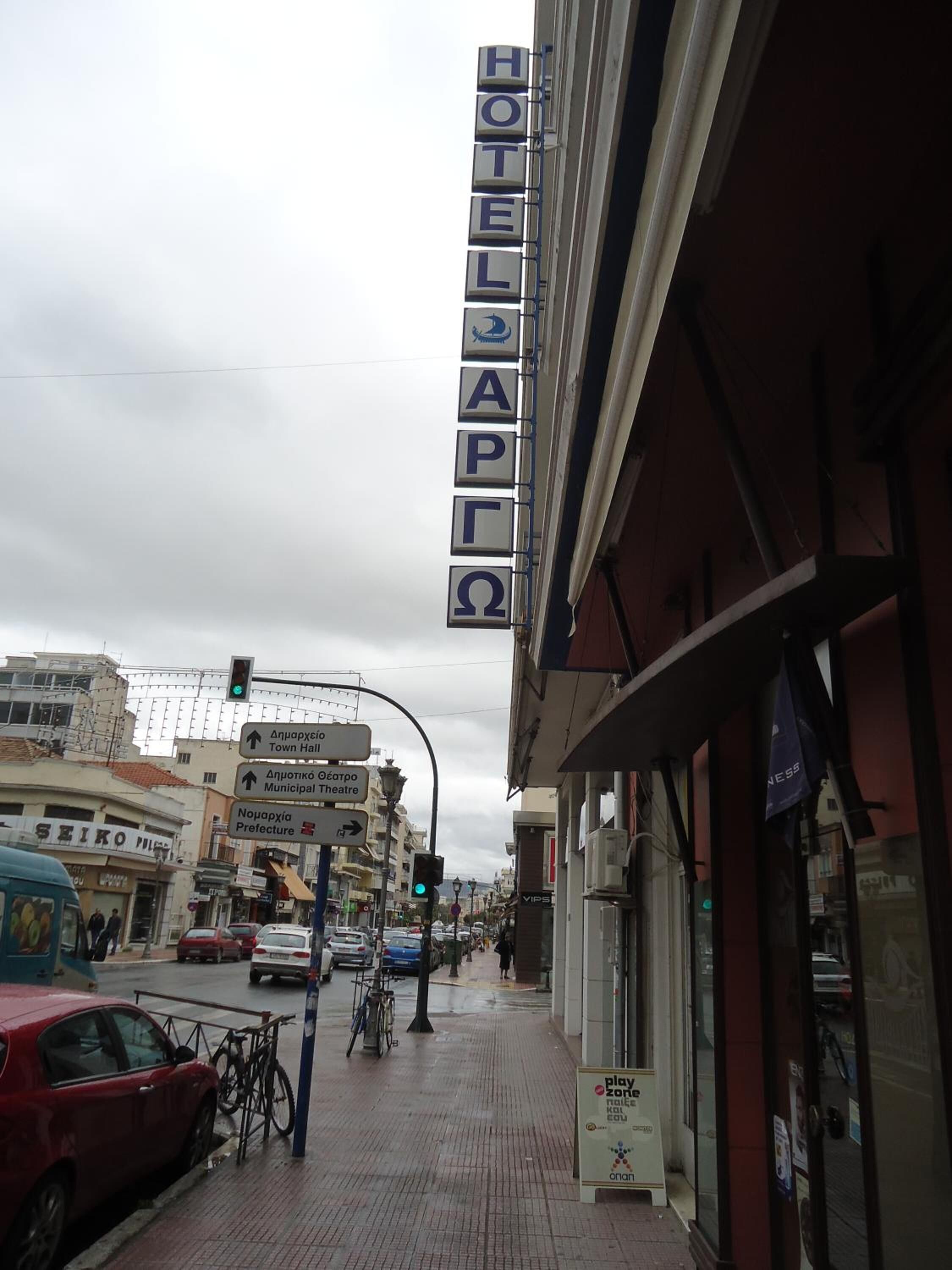 A hotel sign with multiple directional arrows and a traffic light.