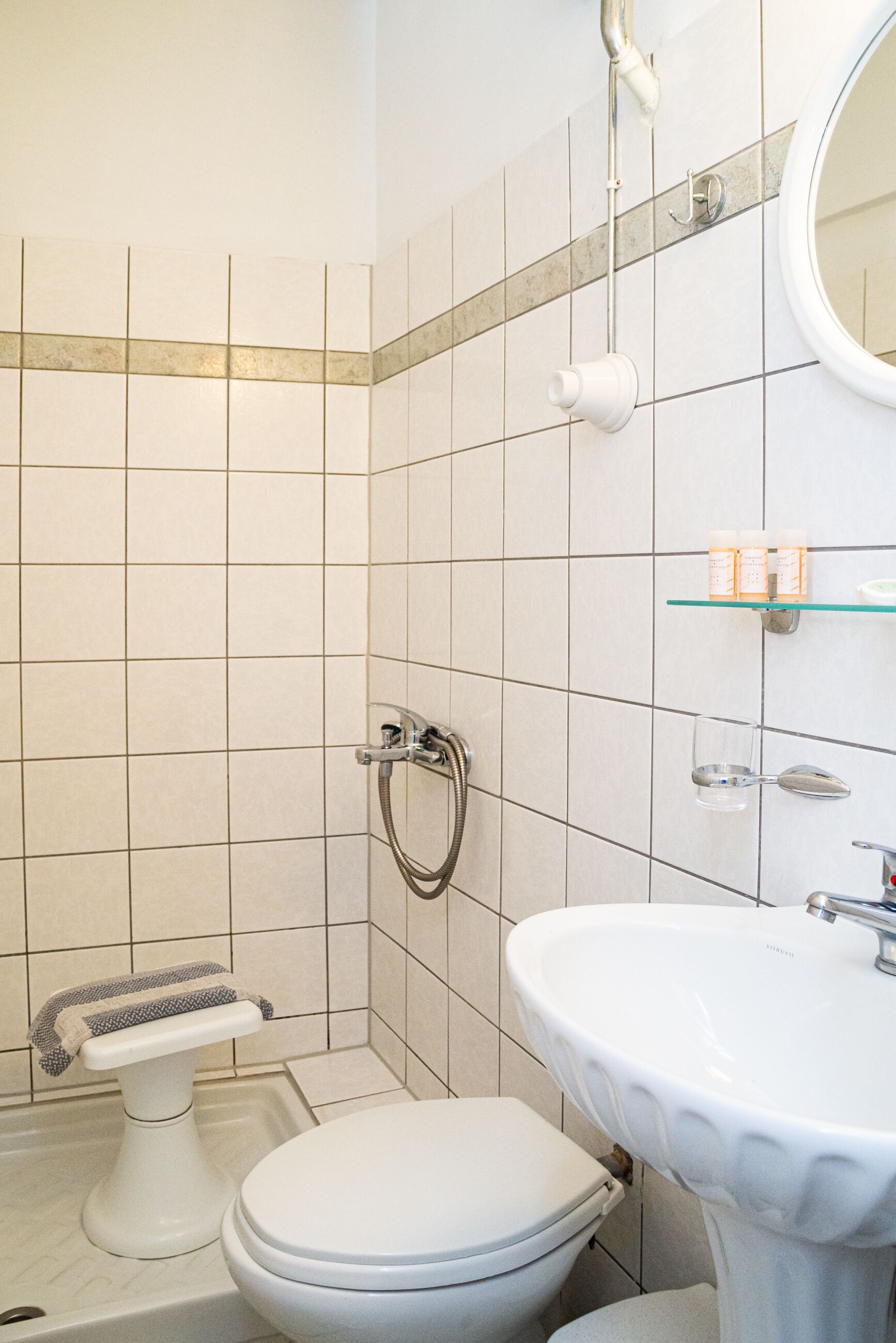A bathroom with a toilet, sink, and shower.