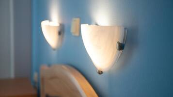A room with a blue wall and two wall-mounted light fixtures.