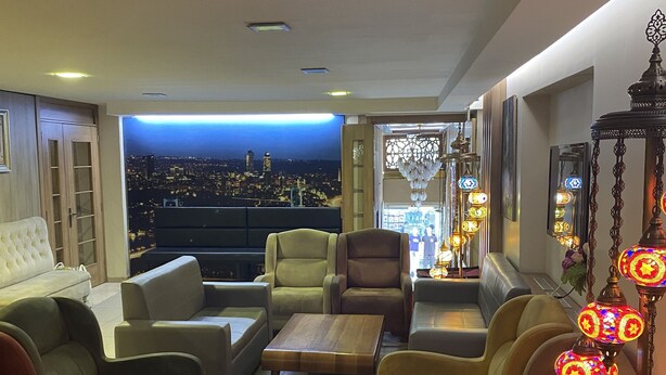 A modern living room with a city view, comfortable seating, and decorative lighting. - Polanin Hotel (Istanbul)