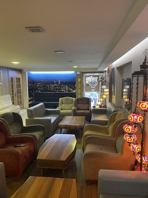A modern living room with a city view, comfortable seating, and decorative lighting. - Polanin Hotel (Istanbul)