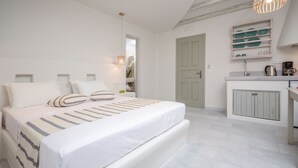 A modern bedroom with a large bed, bedside tables, and a built-in wardrobe. - Agnanti Hotel (Naxos)