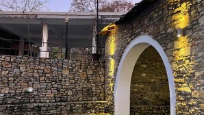 Ein Steinhaus mit einem weißen Bogen und einem Kopfsteinpflasterhof.