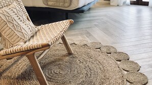 A bedroom with a bed, a woven chair, a stone wall, and a view of the outdoors. - Hotel Ábaco Altea (Altea)