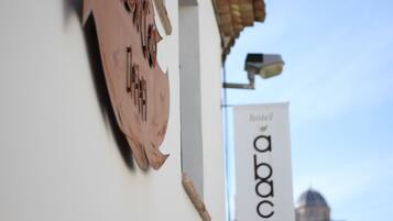 A building with a sign that reads "abaco hotel" and a part of a building with a dome in the background.