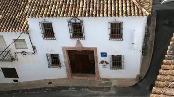 Un edificio blanco con techo de tejas, varias ventanas y una puerta.