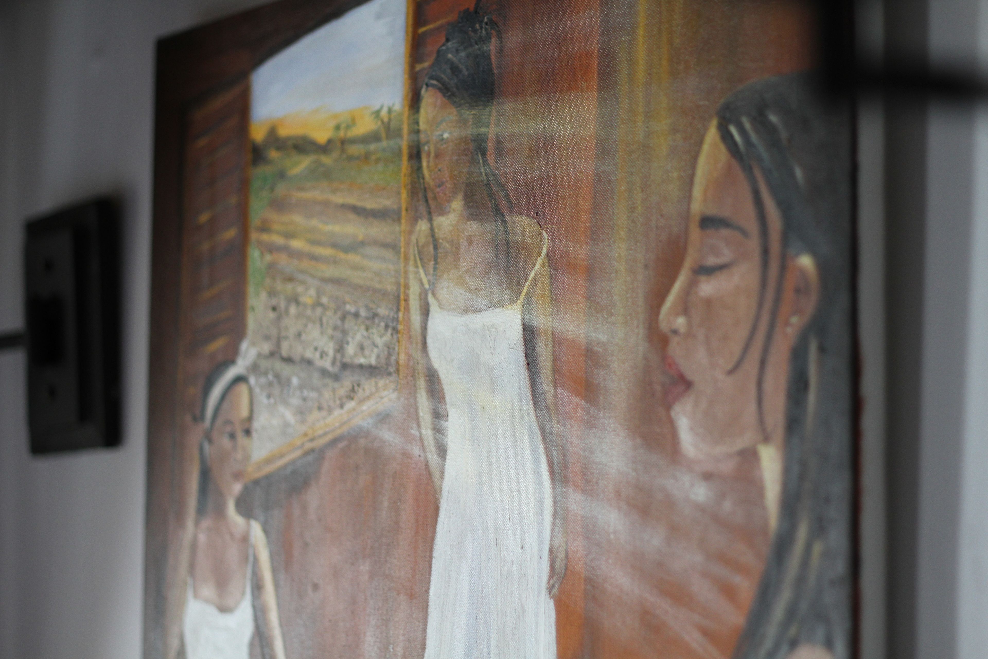 Una pintura de un paisaje y figuras, colgada en una pared.