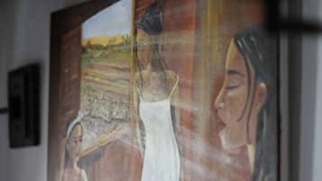 Una pintura de un paisaje y figuras, colgada en una pared.