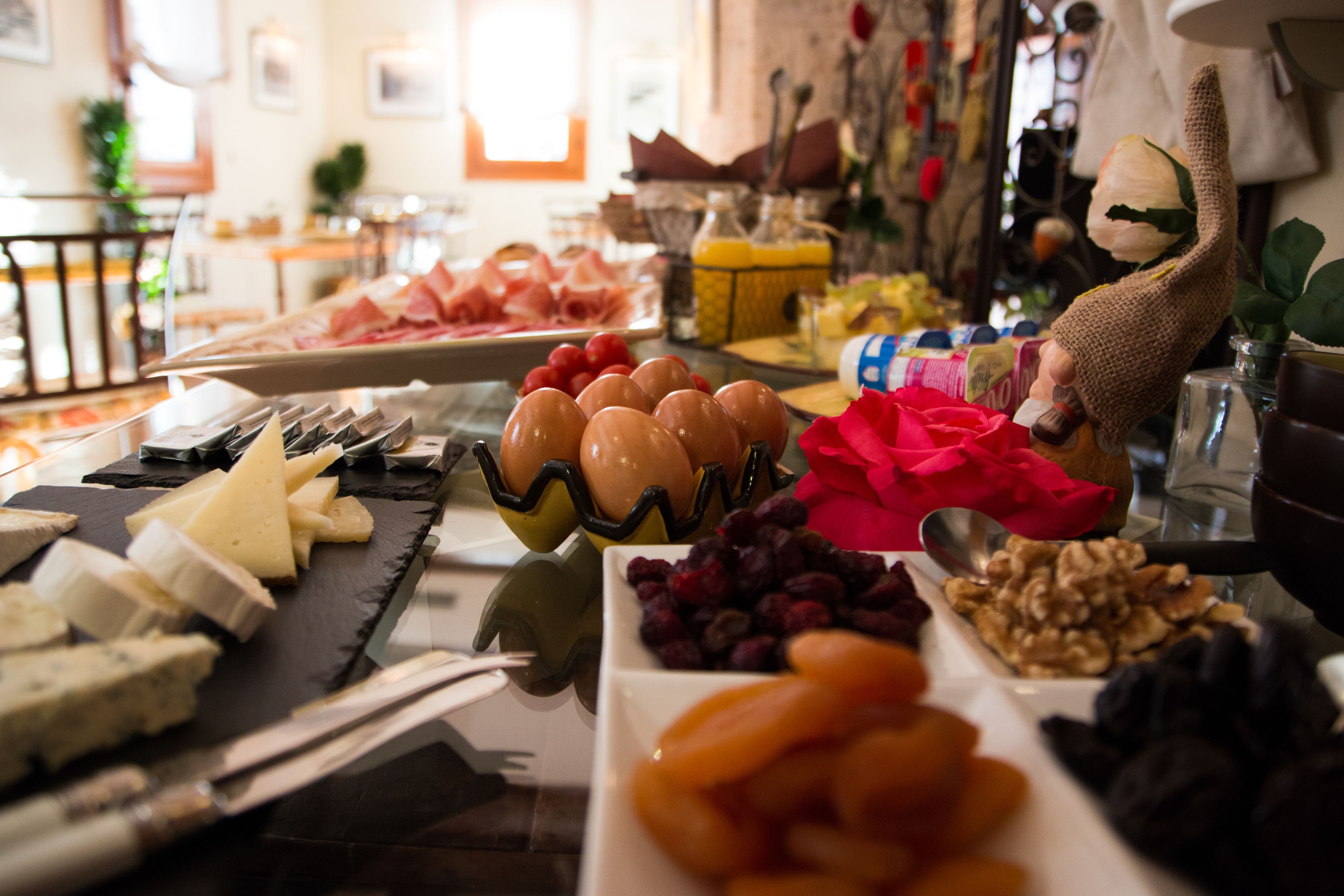 A buffet with various cheeses, fruits, and nuts.