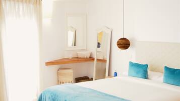 Un dormitorio con cama, mesita de noche, espejo y lámpara colgante.