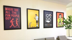 A wall with four framed artworks and a sofa. - Wisma Sentosa (Makassar)