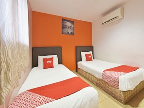 Two single beds with white and red bedding, an air conditioning unit, and a framed picture on the orange wall. - Oyo 90732 New Hotel 33 (Kuala Lumpur)