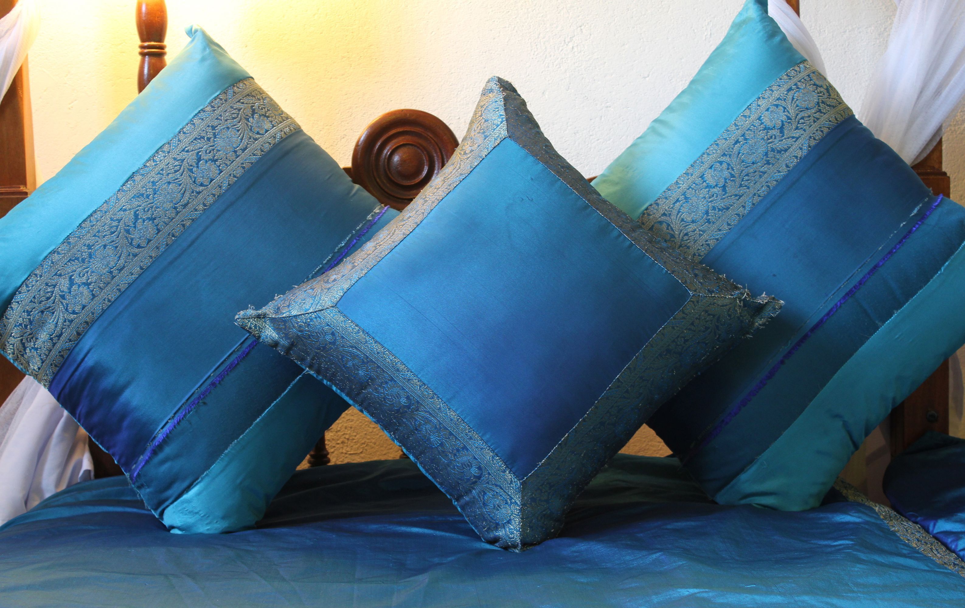 Ein Bett mit blauer Bettwäsche und dekorativen Kissen.
