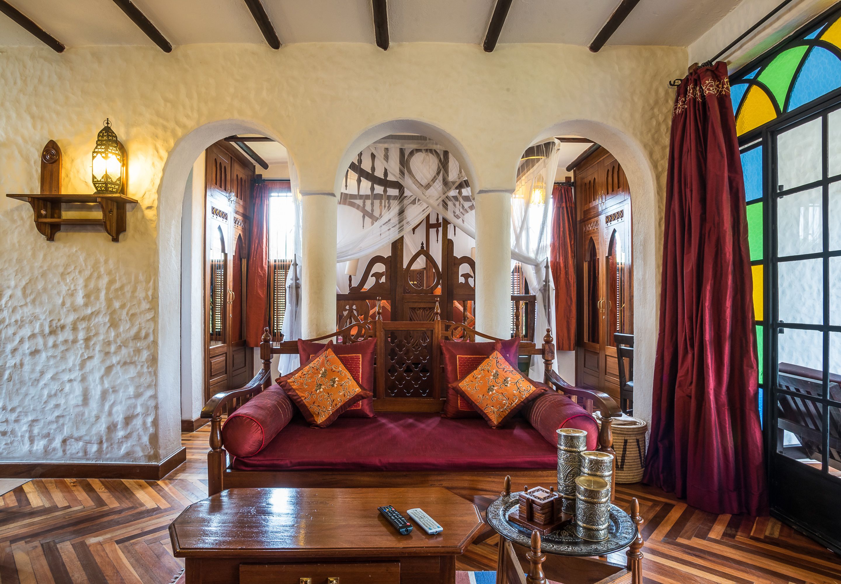 A traditional room with a wooden bed, a coffee table, and a decorative lamp.