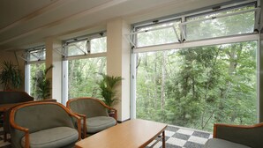 A room with large windows, wooden furniture, and potted plants. - Hakuba PAIPU NO KEMURI (Hakuba)