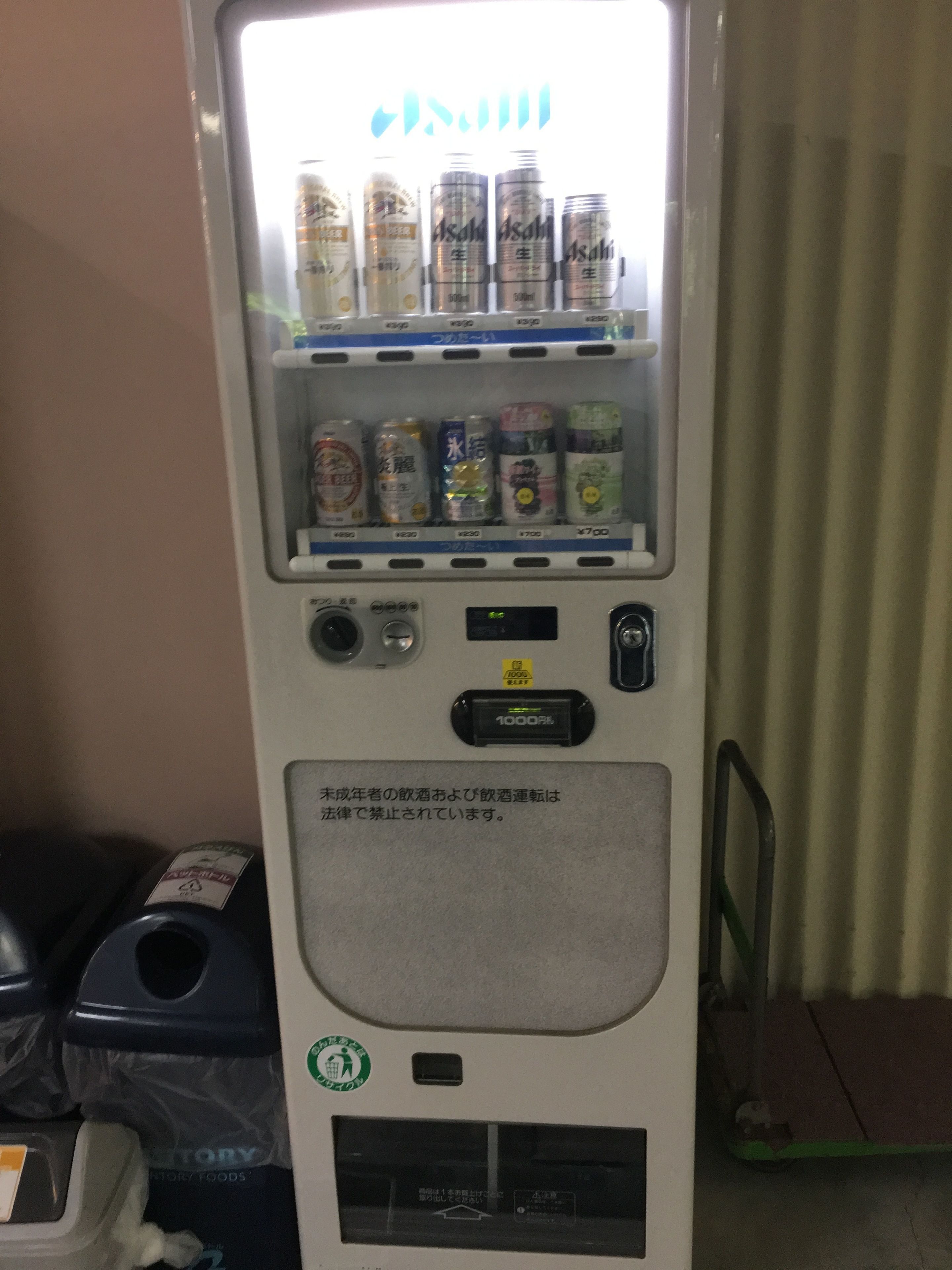 Een automaat met diverse drankjes en een waarschuwing in een vreemde taal.