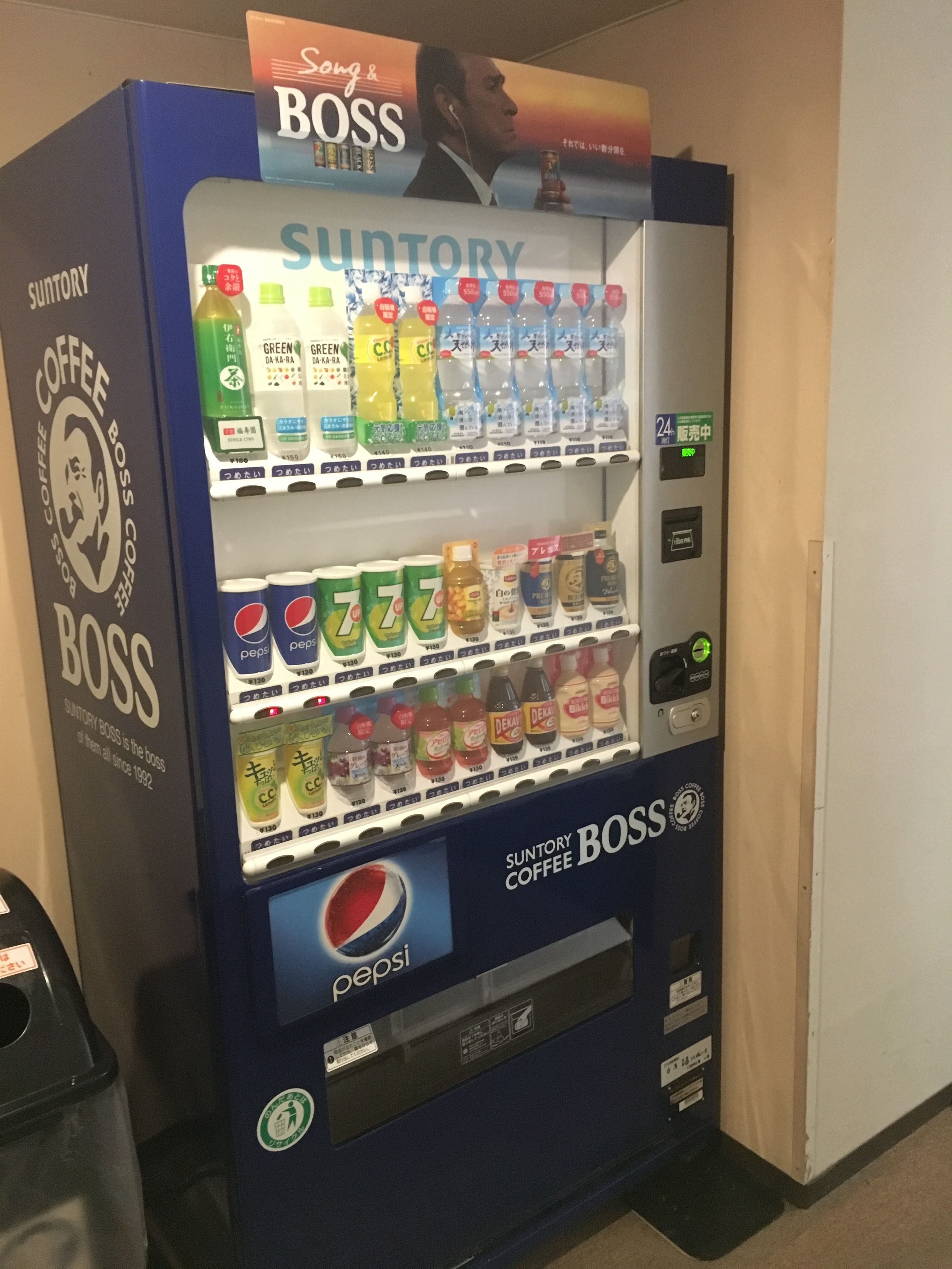 Ein Suntory Coffee Boss Getränkeautomat mit verschiedenen Auswahlmöglichkeiten, darunter auch Pepsi.