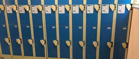 A row of blue lockers with numbered tags, each with a label and a metal latch.