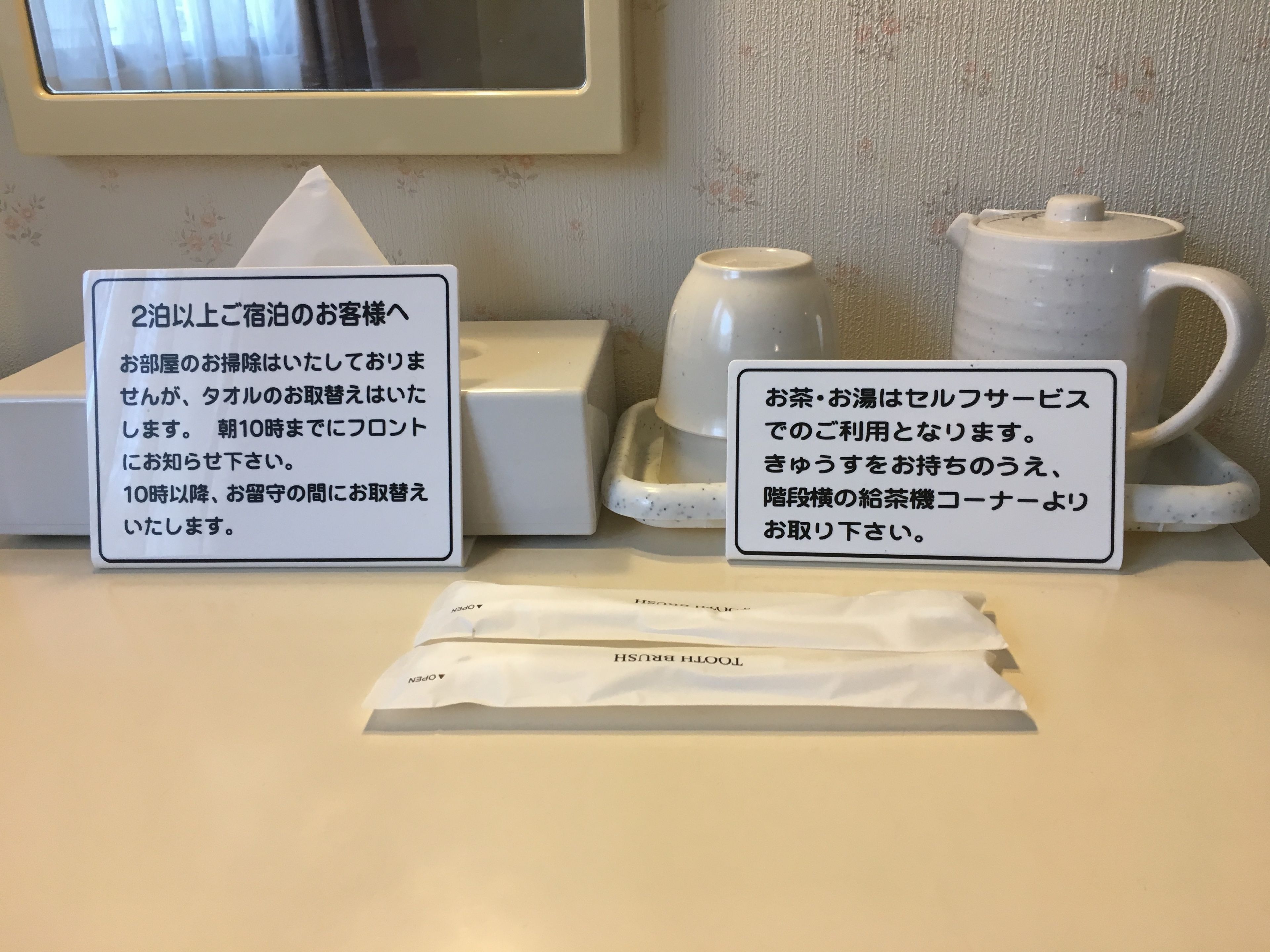 A hotel reception area with a signboard, a teapot, a teacup, and a tissue box.